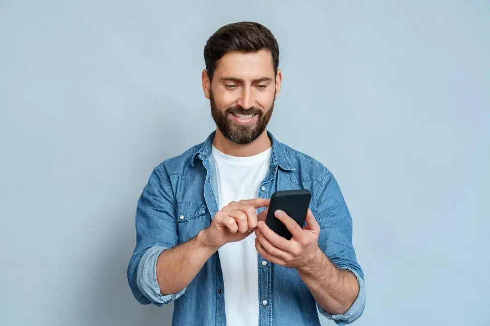 Man using phone and smiling Man using phone and smiling