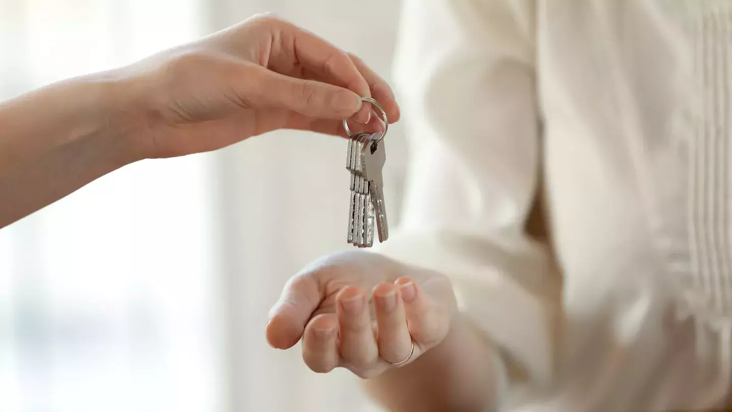 person holding keys person holding keys