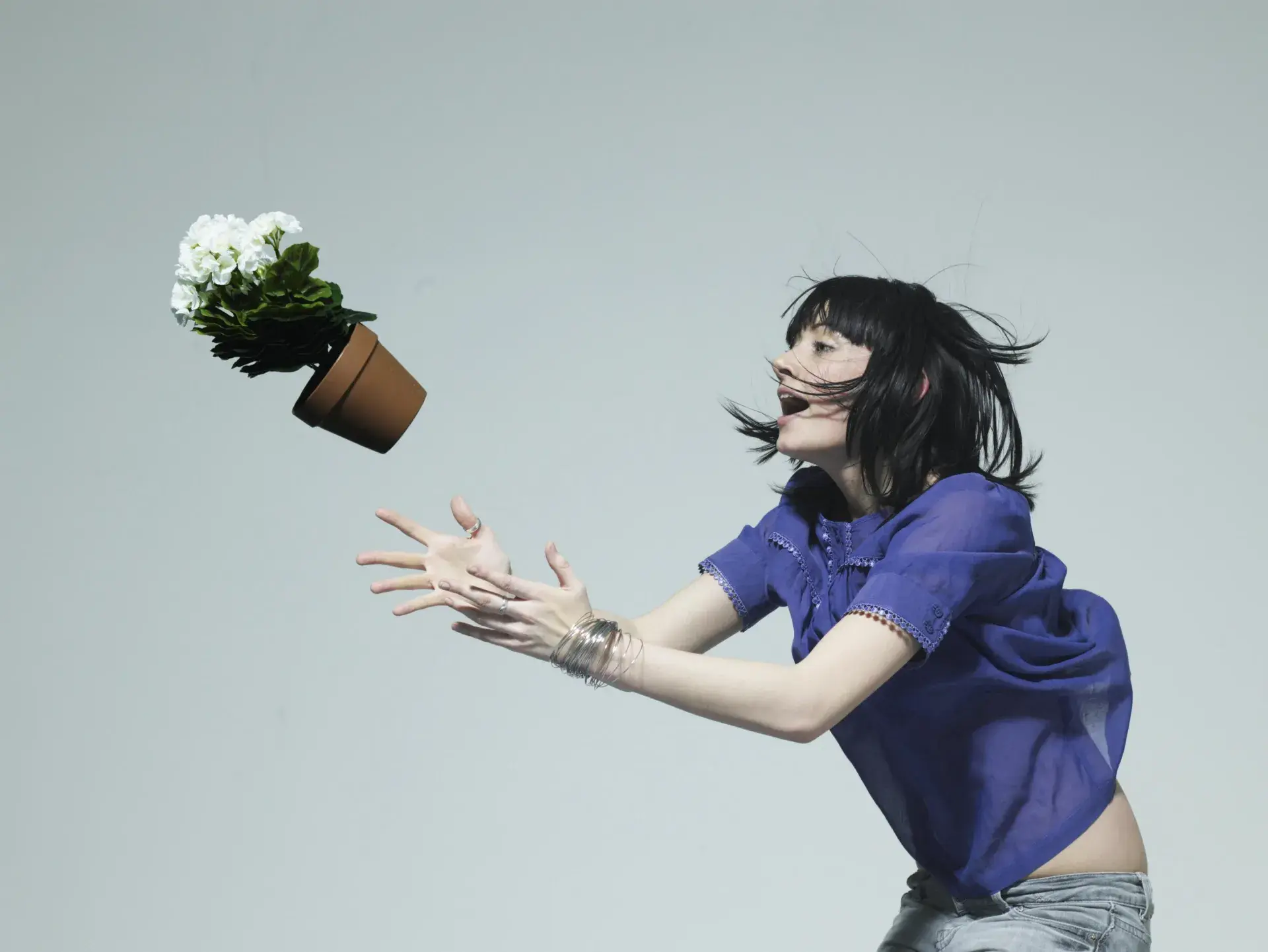 Woman catching a flower pot Woman catching a flower pot